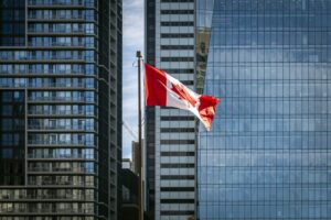 A Canadian flag in front of office high-rises